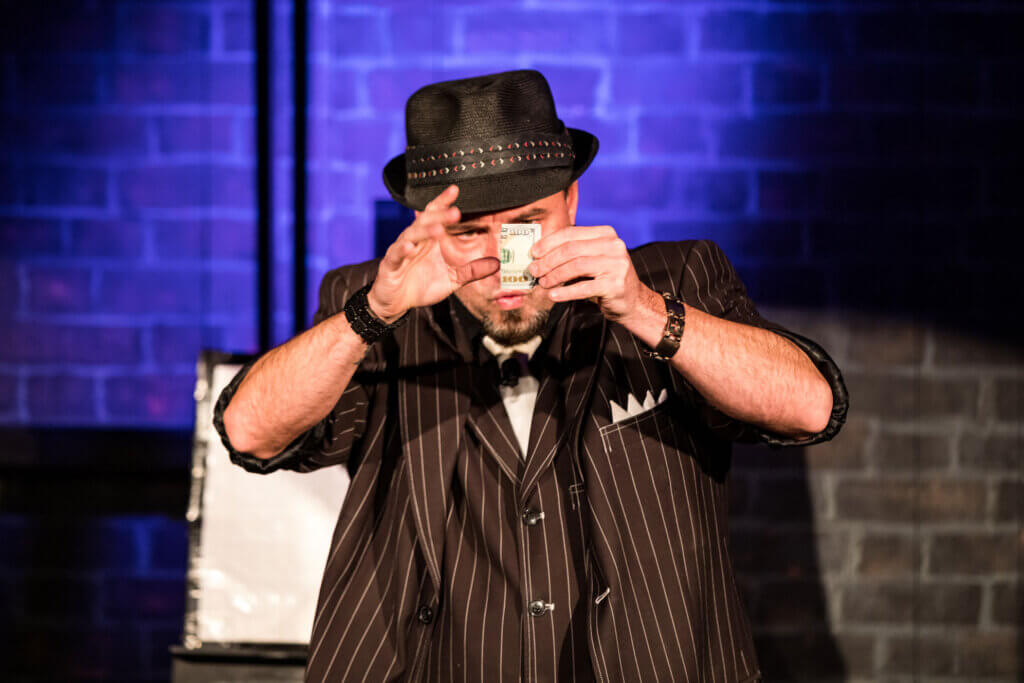 A magician performing a trick for an audience at the Loft