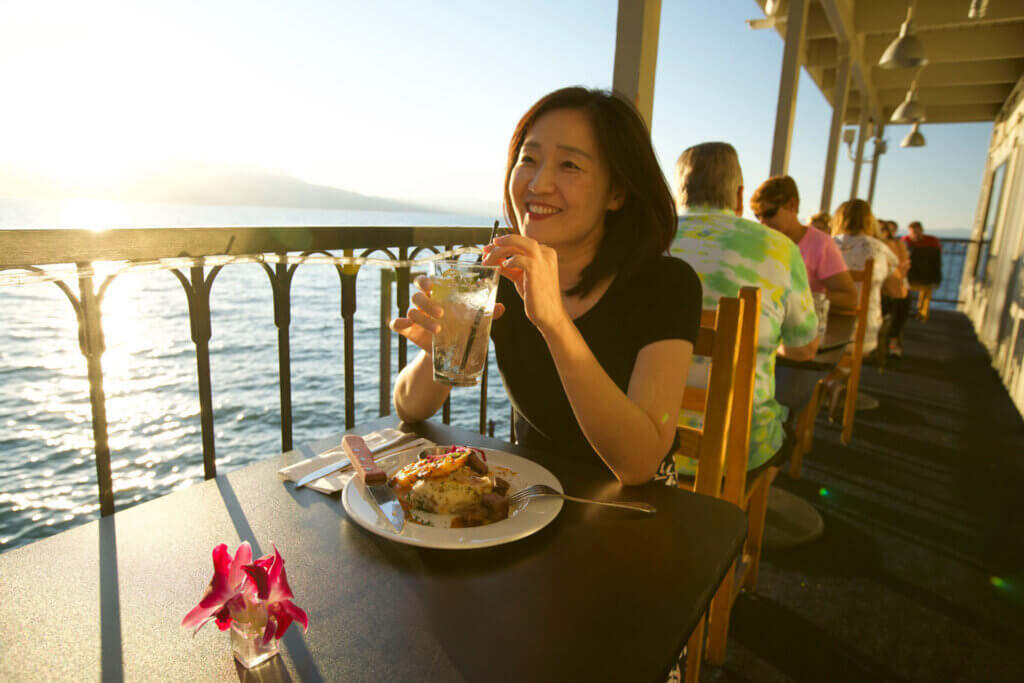 Woman eating outside at the boathouse on the pier