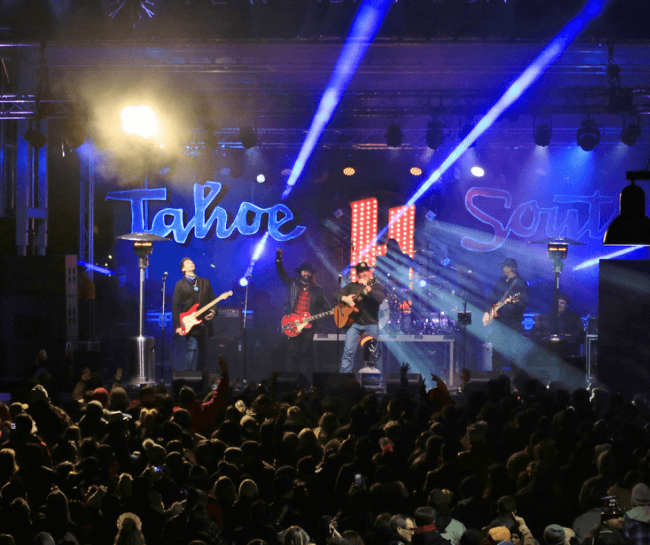 A band on stage performing in front of a crowd with "Tahoe South" behind them